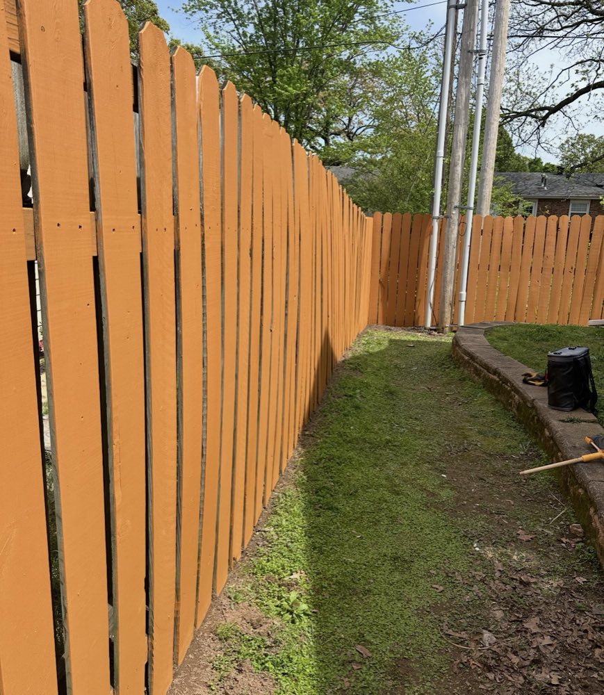 A wooden picket fence freshly painted a warm orange